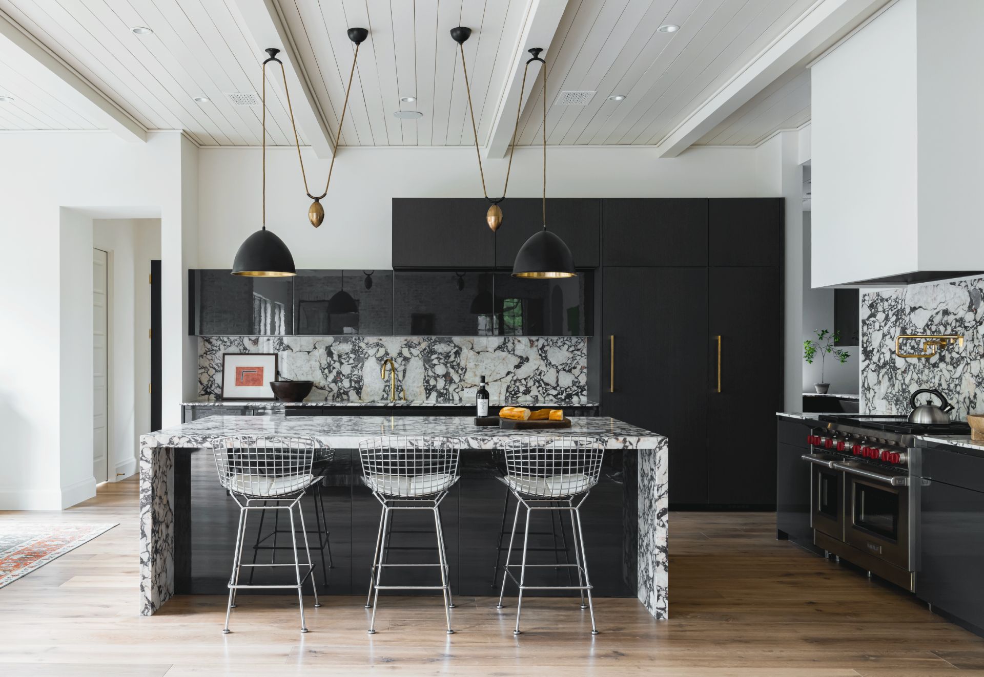 Atrium Contemporary matte black kitchen with waterfall marble island